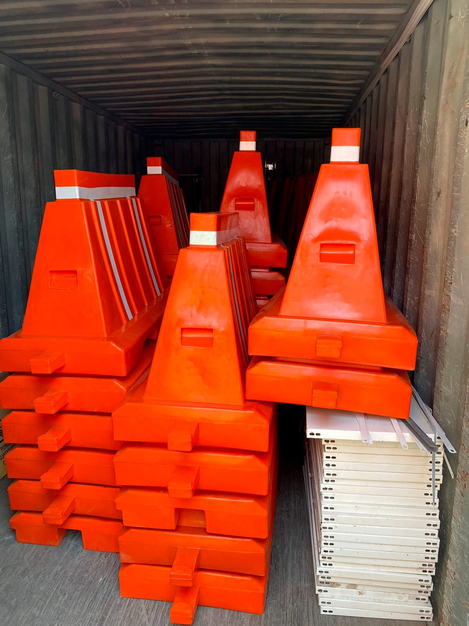 Cones de trânsito laranja e branco empilhados, separadores de estrada para segurança viária