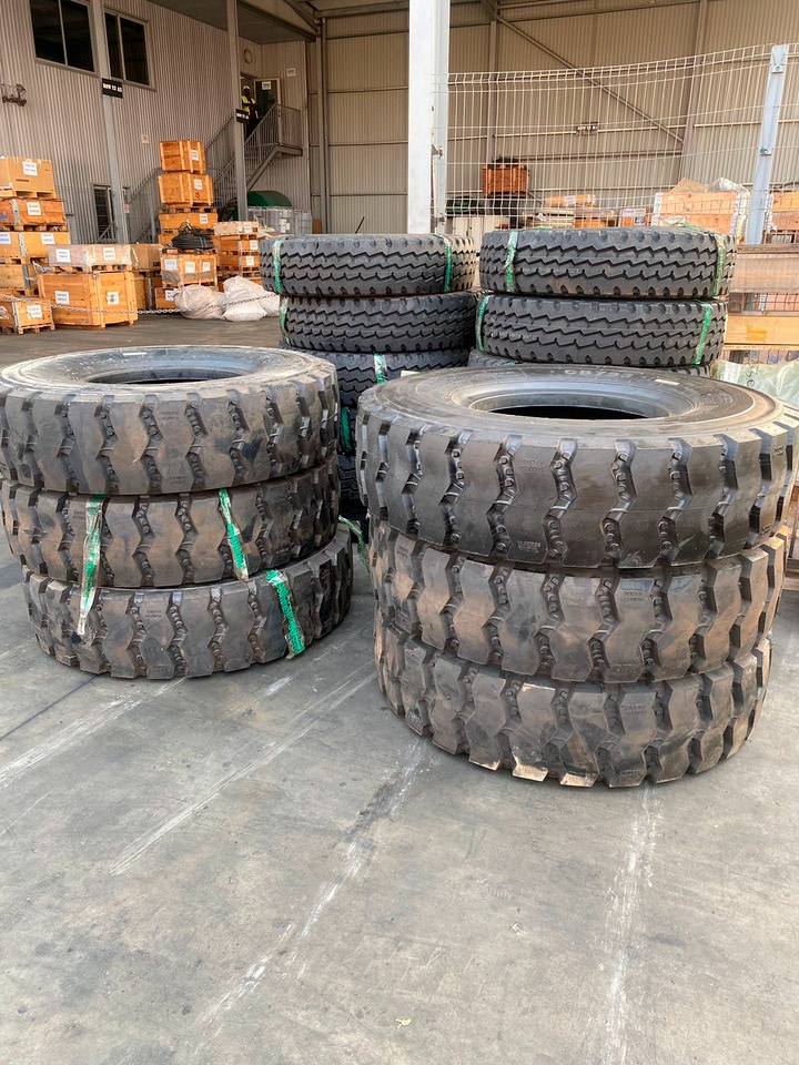 Variedade de pneus novos empilhados, marcas Michelin, Bridgestone, Hankook para diferentes veículos